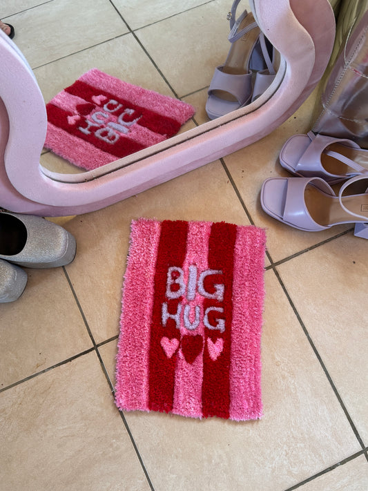 Tapis tufté à la main Aurea Big Hug, rectangulaire, avec larges rayures roses et rouges, texte Big Hug et trois cœurs, design simple et chaleureux pour intérieur